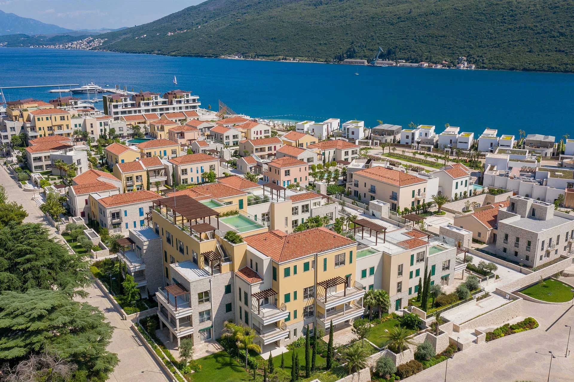 Stunning aerial view of Montenegro's upscale real estate, featuring villas and apartments with scenic waterfront views and modern architecture.